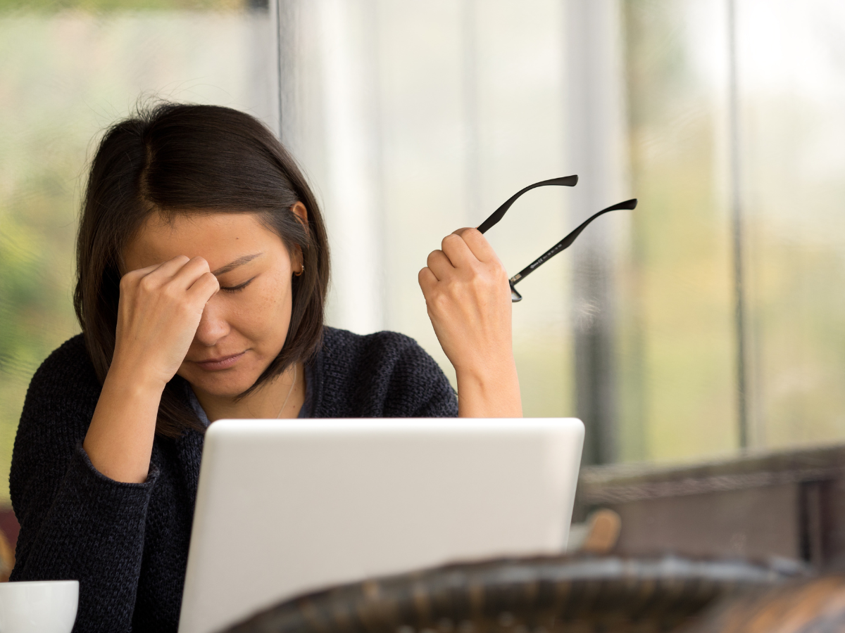 Asian woman gets headache from reporting ecommerce metrics